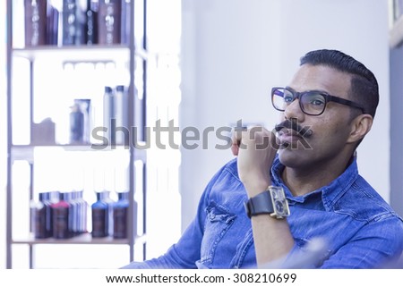 portrait of a thoughtful hairstylist at his barber shop - focus on the eye