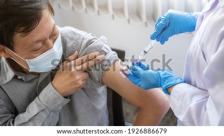 Doctor woman injecting Covid-19 coronavirus vaccine for old man. Fight against Covid-19 coronavirus Concept.