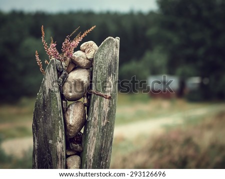Decorative trail marker made of stones, wood and heather