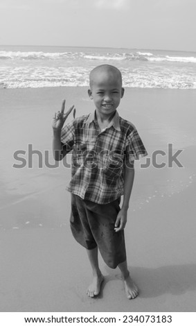 Myanmar, Ngwesaung beach, November 05, 2014. Fun cute boy on the beach. Black and white.