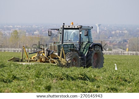 FLORENCE , ITALY - 8 April 2015: a farmer unspecified work the land of the farm in the spring using his tractor. at this time are preparing the fields for future collections