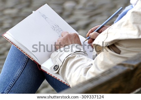 ROME, ITALY 14 June 2015 :An unidentified person draws with a pencil in the public square on a summer day