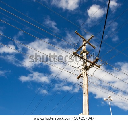 power lines for australian power pole electricity grid against cloudy blue sky