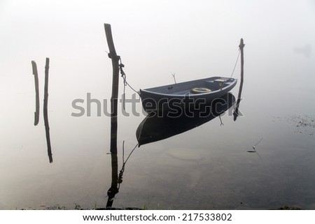 Fishing boat in the lake with fog