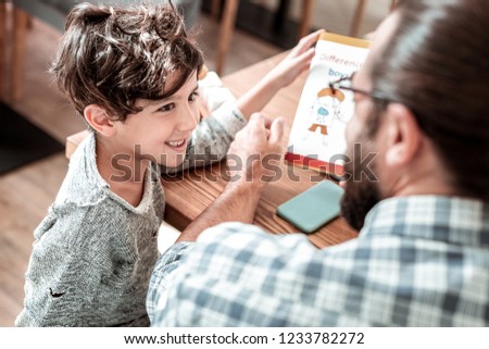 Similar – Image, Stock Photo Father and son reading book together