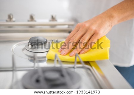 Cleaning. Close up of a human hand cleaning a gas stove