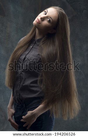 Pretty young woman in casual style standing half length portrait on dark background