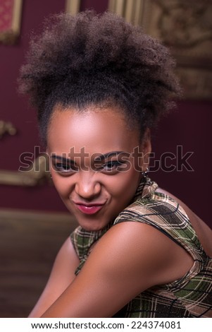 Half-length portrait of great African model wearing lovely dress sitting seductively looking at us