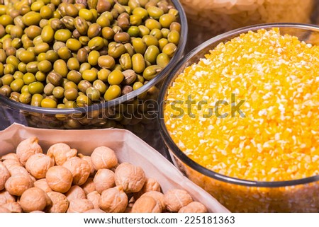 Composition of glasses with cereals like buckwheat maize rice peas haricot millet oats beans poppy seed herbage noodles isolated on white background with copy place