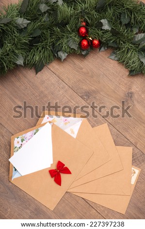 Christmas tree toys and  decoration like envelopes with red bows  with white clear sheet s of paper  and fir branch on wooden table top view  with copy place