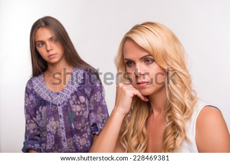 Young sad depressed  mother in the forefront  and daughter isolated on white background selective focus