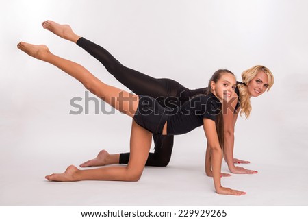 Young sport  mother and  daughter teenager  stretching doing horizontal stand or kneeling and doing leg swing  smiling isolated on white background