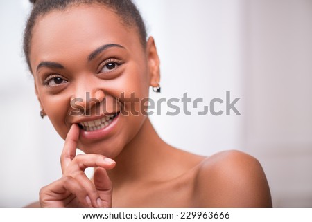 Portrait of beautiful  dark skinned girl in white towel thinking  and touching lips and  opening mouth  looking aside isolated on white background