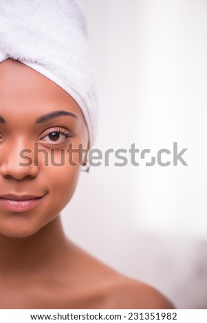 Portrait of beautiful  dark skinned girl in white towel on head looking at camera isolated on white background with copy place