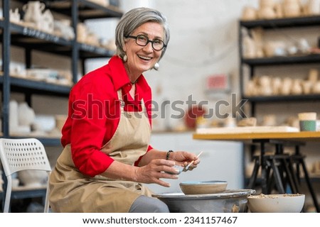 Similar – Image, Stock Photo Craftswoman painting a bowl made of clay in art studio