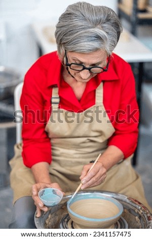 Similar – Image, Stock Photo Craftswoman painting a bowl made of clay in art studio