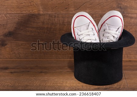 cool youth white gym shoes with red  stripes  on brown parquet  in black top hat like  rabbit wooden floor with copy place