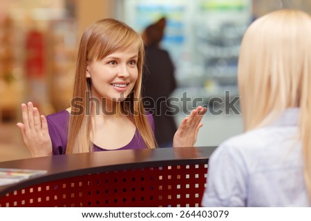 Lost in shopping. Close-up of a young beautiful girl asking for information at the shopping center reception desk