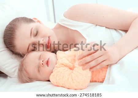 Baby sleep. Portrait of mother sleeping embracing her little child.