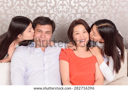 We love you. Portrait of Asian family with two daughters kissing parents