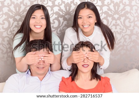 Hide and seek. Family picture of happy Asian family