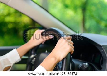 Driving forward. Close up portrait of young woman driving new car.