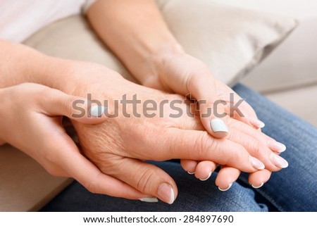Opposite sides. Portrait of young and old ladies hands lying on each other.