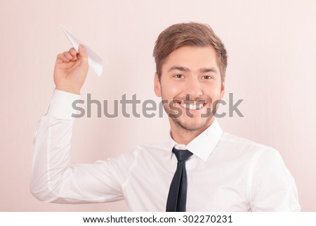 Express yourself. Portrait of vivacious smiling lawyer holding paper plane and smiling while feeling over  the moon