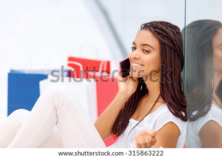 Happy to hear you. Delighted nice young woman holding mobile phone and having brisk conversation  while relaxing