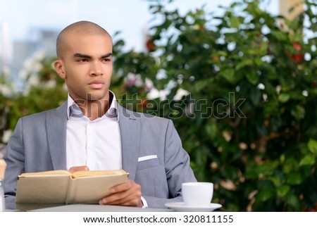 Let me think. Nice thoughtful handsome businessman sitting in the cafe and making notes while thinking