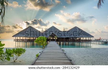 Jetty leading to overwater resort hotel restaurant and arrival
