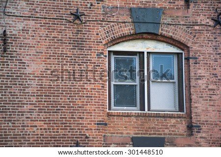 Window with metal grid in an old brick building in Brooklyn