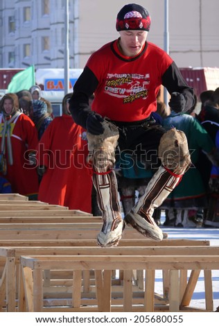 Nadym, Russia - March 15, 2008: the national holiday - the Day of the reindeer herder in Nadym, Russia - March 15, 2008. Sports competitions. Unknown man jumps over obstacles.