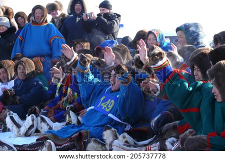 Nadym, Russia - March 15, 2008: the national holiday - the Day of the reindeer herder in Nadym, Russia - March 15, 2008. A crowd of unfamiliar men Nenets sit and watch the view.