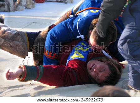 NADYM, RUSSIA - March 11, 2005: National Holiday - Day of the reindeer herders. The wrestling unknown men on holiday in Nadym, Russia - March 11, 2005.