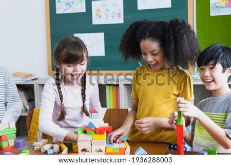 group of Diversity of school students playing wooden blocks in classroom. Elementary school children enjoy learning together. Learn to work as a team. Back to school concept