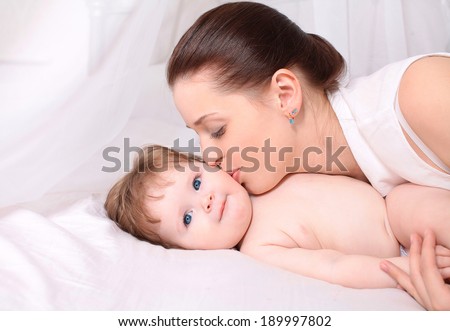 Happy mom tenderly kissing baby, care and love