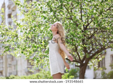 Spring mood, lovely girl blonde enjoying nature in garden, good warm clear day