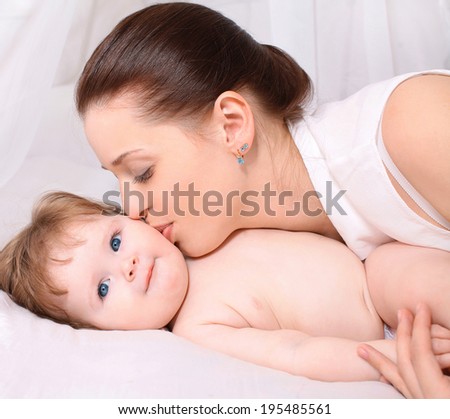 Happy baby and mom tenderly kissing, care and love