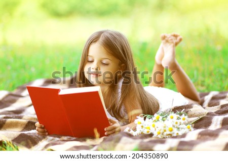 Child reading a book on nature