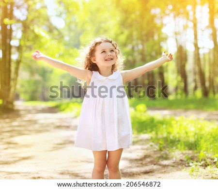 Positive charming curly little girl enjoying summer sunny day, expression emotions, having fun, happy child walking in summer day