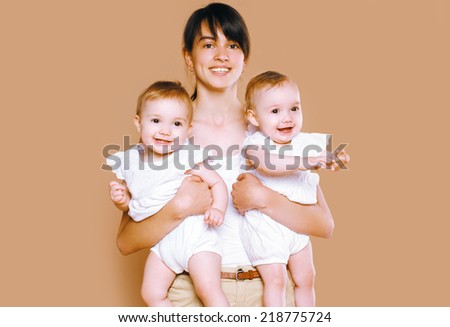 Mother holding on the hands twins baby