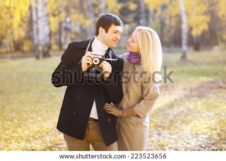 Autumn, love, relationships and people concept - lovely couple in love walking in sunny autumn park