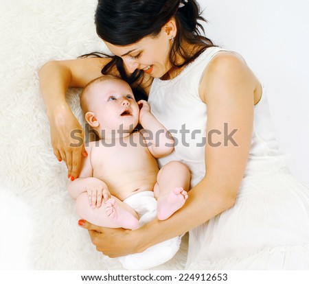 Happy mom and baby lying on the bed