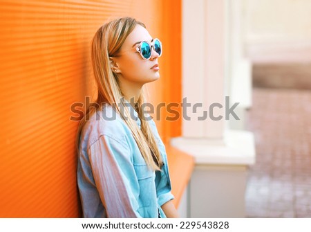 Summer, fashion and people concept - lifestyle portrait stylish pretty woman in sunglasses against colorful wall in city, street fashion