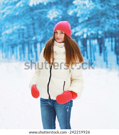 Winter and people concept - pretty woman walking in snowy forest