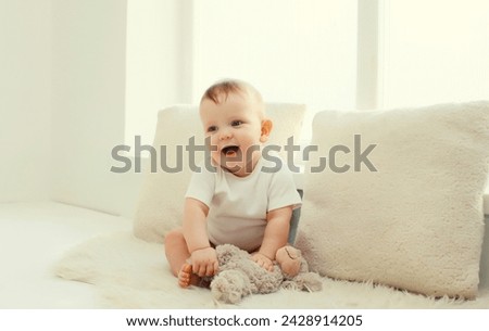 Similar – Image, Stock Photo Curious beautiful baby boy in blue body lying on playing mat, looking in the camera