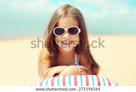 Travel, vacation - sunny portrait of smiling child resting on the beach in the summer day