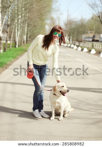 Happy owner and labrador retriever dog outdoors walking in summer day