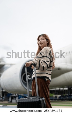 Similar – Image, Stock Photo Female passenger carrying the hand luggage bag, walking the airplane boarding corridor.